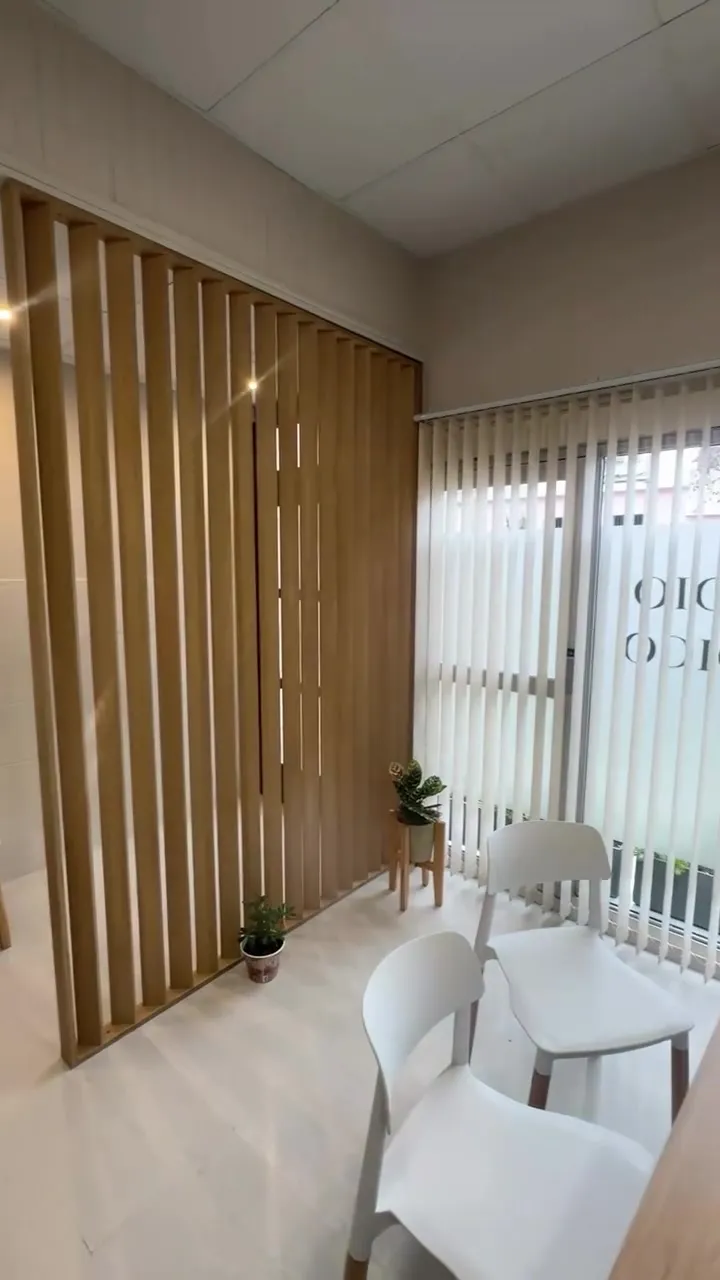 Sala de espera con sillas blancas y listones