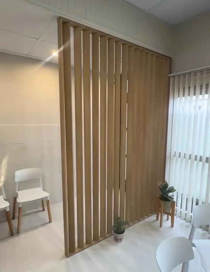 Sala de espera separada por un panel de listones de madera